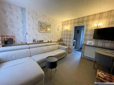a living room with a white couch and a television at Cosy Cottage in Moffat Town Centre - Pass the Keys in Moffat