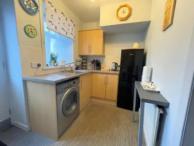 a kitchen with a sink and a washing machine at Cosy Cottage in Moffat Town Centre - Pass the Keys in Moffat