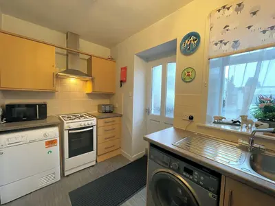 a kitchen with a washer and a sink and a dishwasher at Cosy Cottage in Moffat Town Centre - Pass the Keys in Moffat