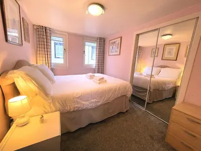a bedroom with two beds and a mirror at Cosy Cottage in Moffat Town Centre - Pass the Keys in Moffat