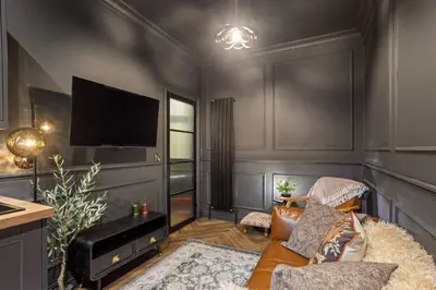 a living room with a couch and a flat screen tv at Boutique Studio Near Stirling in Cambusbarron