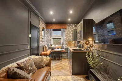a living room with a couch and a kitchen at Boutique Studio Near Stirling in Cambusbarron