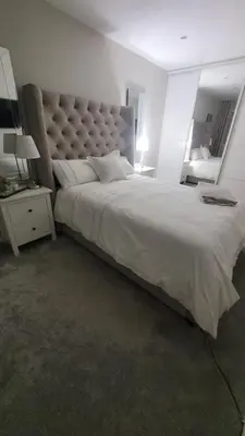 a bedroom with a large bed with a large headboard at Stylish, Modern 3 bedroom house, free parking x 2 in Mansewood