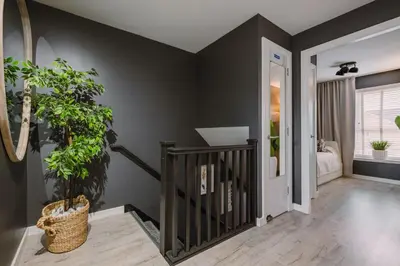 a hallway with black walls and a staircase with plants at JW Canmore ApartHouse in Glasgow