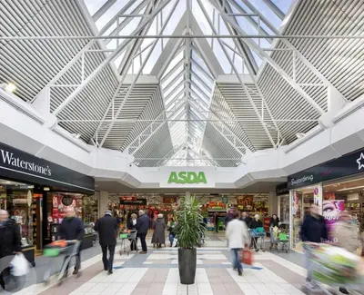 a group of people walking through a shopping mall at Newton Mearns Home in Newton Mearns