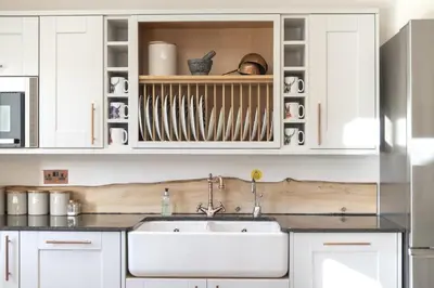 a kitchen with white cabinets and a sink at The Steading In The Park in Stirling