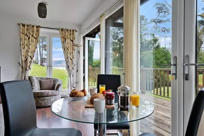 a dining room with a glass table and chairs at Turbine House in Lochgilphead