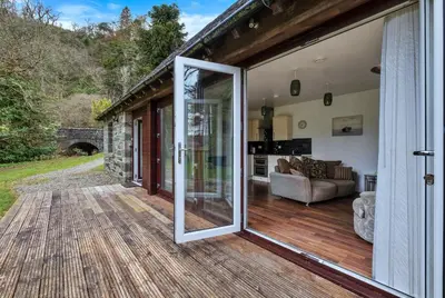 an open sliding glass door on a house with a patio at Turbine House in Lochgilphead