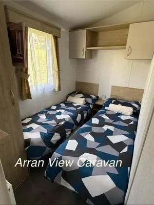 two beds in a small room withacers at Arran View Caravan in Ayr