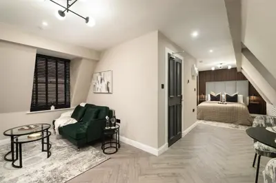 a living room with a green couch and a bed at South Lane Apartments - City Centre in Edinburgh