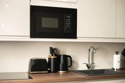 a kitchen counter with a microwave and a sink at South Lane Apartments - City Centre in Edinburgh