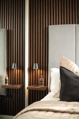a bedroom with a bed and two night stands with lamps at South Lane Apartments - City Centre in Edinburgh
