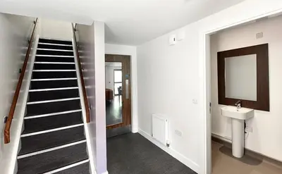 a hallway with a staircase and a sink in a house at Alexander Court Townhouse in Stirling
