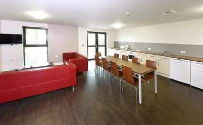 a living room with a red couch and a table at Alexander Court Townhouse in Stirling