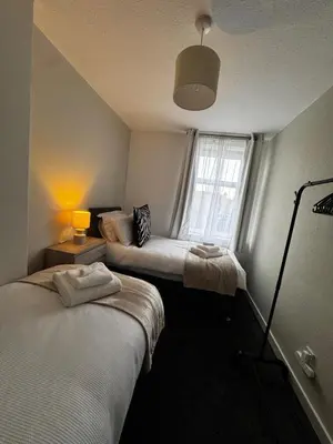a room with two beds and a window at Anchor stays - your steady base away from home in Cambusnethan