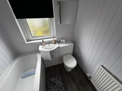 a small white bathroom with a toilet and a sink at Anchor stays - your steady base away from home in Cambusnethan