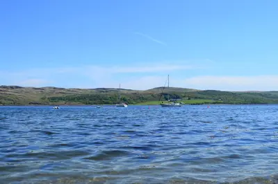 a large body of water with a boat in it at Pier Cottage at Kames in Kames
