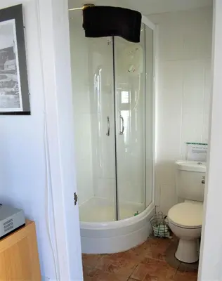 a bathroom with a shower and a toilet at Pier Cottage at Kames in Kames