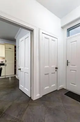 an empty room with two white doors and a kitchen at Stirling Edwardian House - Fireplace,Garden,Parking in Stirling