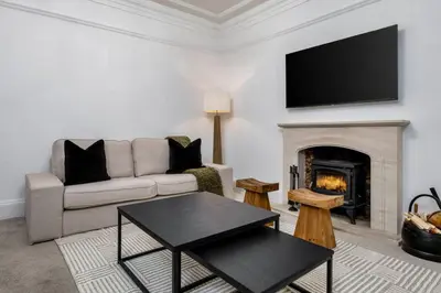 a living room with a couch and a fireplace at Stirling Edwardian House - Fireplace,Garden,Parking in Stirling