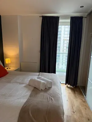 a hotel room with a bed with a towel on it at Stylish Clyde Riverfront Flat with Balcony Views in Glasgow