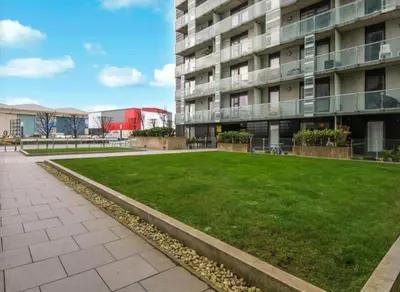 a grassy area in front of a building at Stylish Clyde Riverfront Flat with Balcony Views in Glasgow
