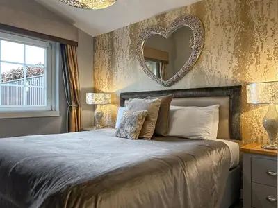 a bedroom with a large bed with a mirror on the wall at Conemara - Uk51249 in Glasgow