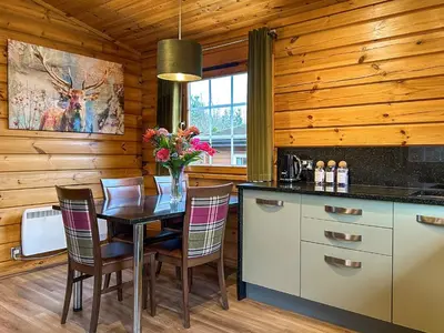 a dining room with a table and chairs in a kitchen at Lodge 2 - Uk51263 in Glasgow