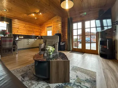 a living room with a table and a kitchen at Lodge 2 - Uk51263 in Glasgow