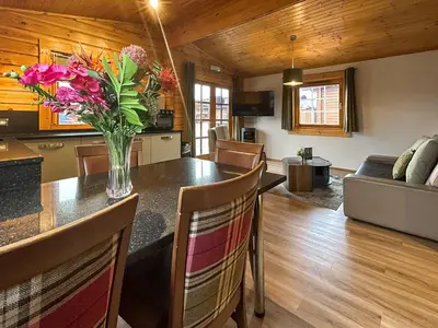 a kitchen and living room with a vase of flowers on a table at Lodge 2 - Uk51263 in Glasgow