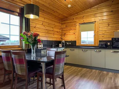 a kitchen with a table with a vase of flowers on it at Lodge 2 - Uk51263 in Glasgow