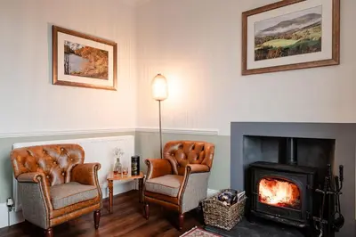 a living room with two chairs and a fireplace at Fir Tree Lodge - Seasgair Lodges in Crieff