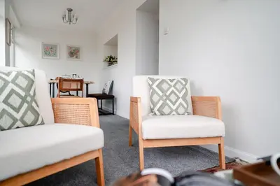 a living room with two chairs and a table at Fir Tree Lodge - Seasgair Lodges in Crieff