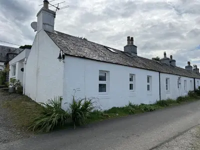 a white building on the side of a street at Mid- Village Croft in Cairndow