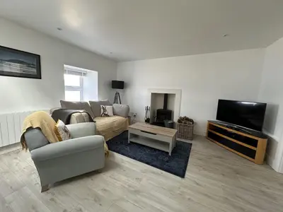 a living room with a couch and a tv at Mid- Village Croft in Cairndow