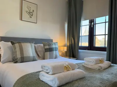 a bedroom with a bed with towels on it at Central 1BR Apt with Parking in Auchterarder