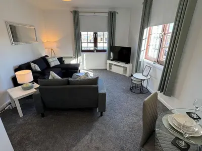 a living room with a couch and a tv at Central 1BR Apt with Parking in Auchterarder