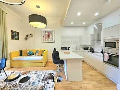 a kitchen and living room with a couch and a table at Stellar Apartments - 2 & 3 Bedroom Apartments in Edinburgh