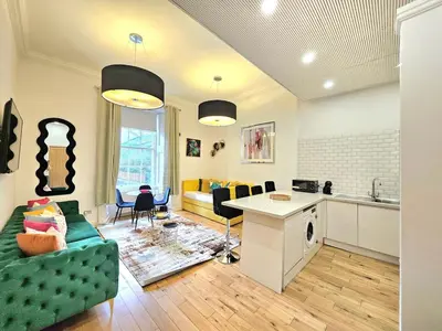 a kitchen and living room with a couch and a table at Stellar Apartments - 2 & 3 Bedroom Apartments in Edinburgh