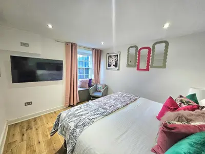 a bedroom with a bed and a flat screen tv at Stellar Apartments - 2 & 3 Bedroom Apartments in Edinburgh