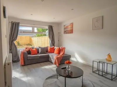 a living room with a couch and a table at Etive House - 3 bedroom stylish home in Cumbernauld