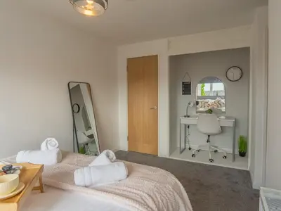 a bedroom with two beds and a desk and a mirror at Etive House - 3 bedroom stylish home in Cumbernauld