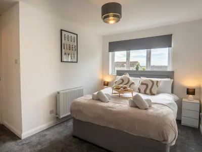a bedroom with a large bed with two pillows at Etive House - 3 bedroom stylish home in Cumbernauld