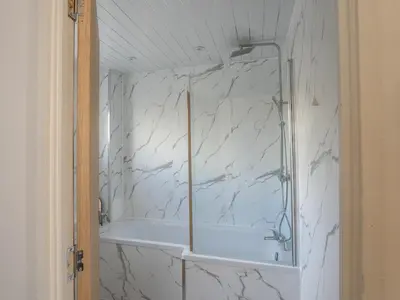 a bathroom with a shower with a white marble wall at Etive House - 3 bedroom stylish home in Cumbernauld
