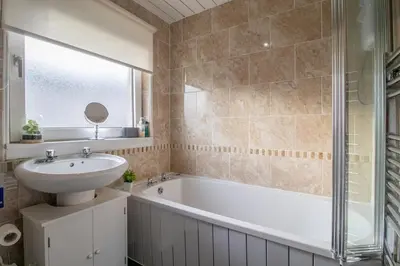 a bathroom with a sink and a bath tub and a mirror at Culzean House - 2 Bedrooms in Coatbridge in Coatbridge