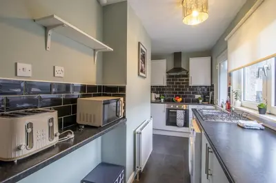 a large kitchen with a counter top and appliances at Culzean House - 2 Bedrooms in Coatbridge in Coatbridge