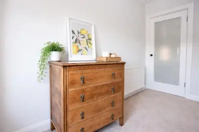 a wooden dresser with a picture on top of it at Portside Apartment in Greenock