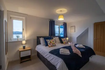 a bedroom with a bed and a window at Lynwood - 4 Bedroom House with Views of Loch Gilp in Ardrishaig