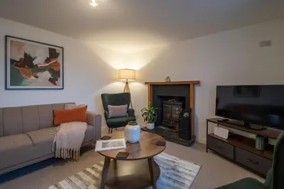 a living room with a couch and a tv at Lynwood - 4 Bedroom House with Views of Loch Gilp in Ardrishaig