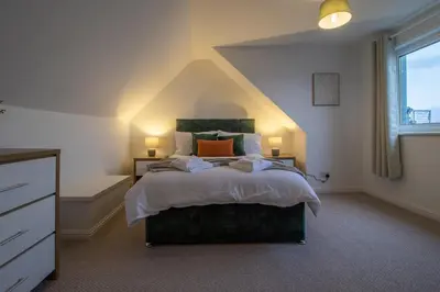 a bedroom with a large bed and a window at Lynwood - 4 Bedroom House with Views of Loch Gilp in Ardrishaig